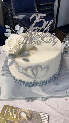 a white cake sitting on top of a table covered in frosting and silver decorations