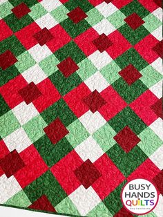 a red, green and white quilt with squares on it