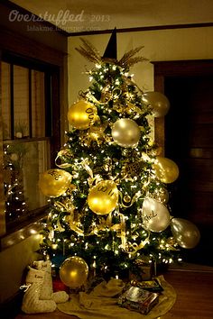 a christmas tree decorated with gold and silver ornaments