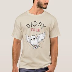 a man wearing a t - shirt that says daddy to be with an owl on it