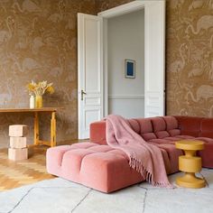 a living room filled with furniture and walls covered in wallpaper