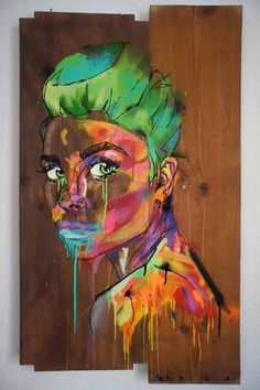 a painting of a woman's face with green hair and splatters on it