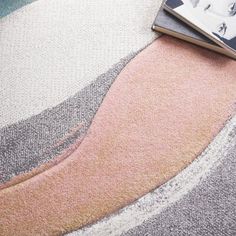 a book sitting on top of a rug next to a magazine