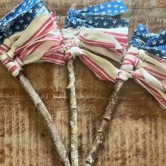 three small american flags on sticks in the shape of stars and stripes, tied together with twine