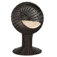 a wicker egg chair with a white cushion on it's back and side