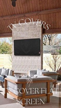 an outdoor living area with couches, tables and a television mounted to the wall