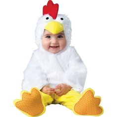 a baby wearing a chicken costume sitting on the ground