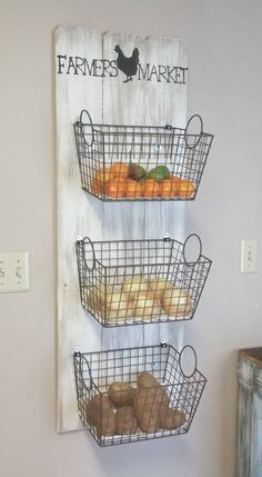 three wire baskets are hanging on the wall