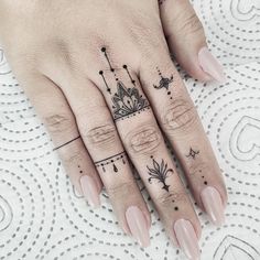 a woman's hand with tattoos on it and a crown tattoo on the middle finger