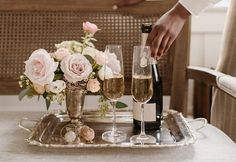 a tray with champagne and flowers on it