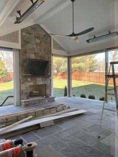 the inside of a house that is being built with stone and glass doors open to an outside patio area