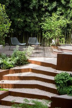 an outdoor garden with steps leading up to the deck and seating area, surrounded by bamboo trees