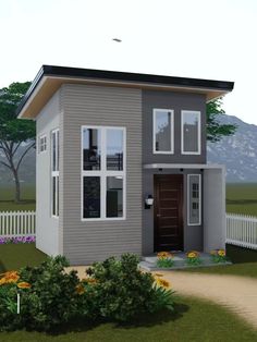 a small gray house with white picket fence and flowers in the front yard, on a sunny day