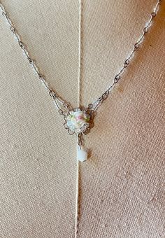 Colleen Toland Sweetheart Pink Rose Pendant Necklace. This is a beautiful necklace by Colleen Toland, featuring a pink rose pendant that is accented by small crystal beads and a crystal satin drop. The necklace has a wire-wrapped chain with rainbow crystal beads . The lobster claw clasp allows you to adjust the length of the necklace from 16 to 20 inches, and there is a metal tag with Colleen's name on it at the end of the chain. This is a lovely piece of jewelry that will make you feel like a s Whimsical White Flower Necklace, Charming Adjustable Jewelry For Wedding, Heart-shaped Jewelry With Flower Charm For Wedding, Heart-shaped Wedding Jewelry With Flower Charm, Feminine Flower Necklaces For Wedding, Feminine Rose Design Necklaces For Wedding, Feminine Rose Design Necklace For Wedding, Feminine Rose Design Wedding Necklace, Charming Necklaces For Wedding