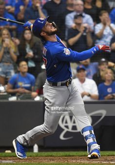 a baseball player is swinging his bat at the ball in front of an excited crowd