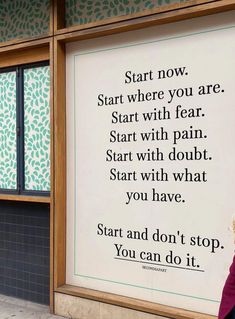 a woman walking past a sign that says start and don't stop