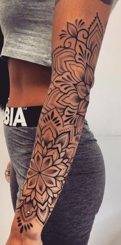 a woman's arm with an intricate tattoo design on her left arm and wrist