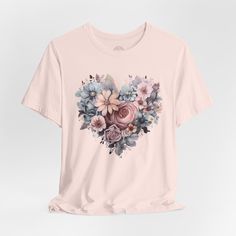 Introducing our new spring t shirt featuring the beautiful image of wildflowers in a shape of heart. This t shirt is perfect for any nature and outdoor lovers and those who find and appreciate the beauty in simple things in life. Stand out with this unique and stylish piece or gift one to any nature and flower lovers. .: Made with 100% Airlume combed and ring-spun cotton, a lightweight fabric (4.2 oz/yd² (142 g/m that is easy to layer, breathable. Perfect for active and leisure wear.  .: Fabric Spring Graphic Tee With Heart Design, Spring Heart Print Crew Neck T-shirt, Spring Heart Print Crew Neck Tops, Pink Graphic Tee With Plant Print, Pink Graphic Tee With Plants Print, Spring Cotton T-shirt With Rose Print, Spring Heart Graphic Tee, Spring Short Sleeve Top With Heart Graphic, Spring Heart-shaped Graphic Tee