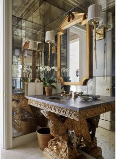 a bathroom with a mirror, sink and potted plants