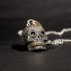 ¡Este es el colgante de calavera más malo que encontrarás en cualquier lugar! Inspirado en las calaveras ornamentadas del Día de los Muertos en México, el cautivador detalle presenta calaveras en miniatura en cada cuenca ocular y tallas intrincadas, y un medallón de la Virgen de Guadalupe.

 La profundidad incomparable de cada pieza, creada por el contraste del latón de joyero sobre la plata brillante, hace que sea imposible no sorprenderse. Con el verdadero pináculo de la orfebrería, cada pieza se elabora a mano en pequeños lotes con una increíble atención a la calidad.

 Como parte de nuestra colección exclusiva Las Calaveras, ¡combínalo con nuestro anillo Calavera Sugar Skull para completar el look!

 Llega listo para usar, nada más sacarlo de la caja.

 Material: Plata de Ley con lató Skull Santa, Sugar Skull Ring, Sugar Skull Necklace, Eye Socket, Intricate Carving, Mexican Day Of The Dead, Padlock Necklace, Day Of The Dead Skull, Skull Pendant Necklace