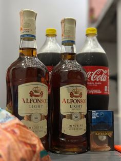 three bottles of alcohol sitting on top of a counter