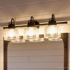 a bathroom vanity with three lights and a mirror