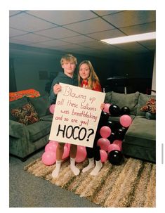 two people standing next to each other holding a sign that says boozing up all the balloons were breaking and so are you?