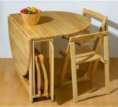 a wooden table with two chairs and a bowl of fruit