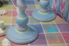 two blue candles sitting on top of a checkered table cloth with other items around it