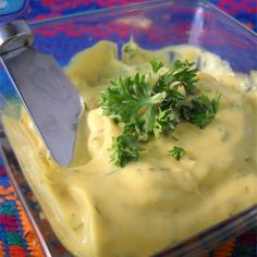 a glass container filled with mashed potatoes and parsley