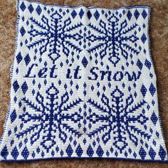 a blue and white crocheted square on the ground