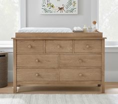 a baby's bed and dresser in a room