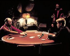 three men sitting around a table playing cards