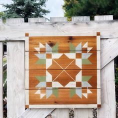 a wooden fence with a patchwork design on the top and bottom part of it