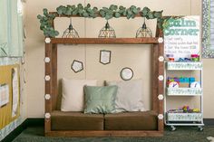 a couch sitting under a wooden frame with pillows on it's back and some decorations hanging from the ceiling