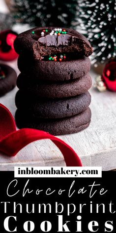 chocolate thumbprint cookies stacked on top of each other next to a christmas tree and red ribbon