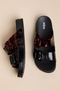 Make your casual days fashionable and extra fun with the Melissa Cozy Black and Clear Tortoise Slide Sandals! A chic combo of black and tortoise print adorns lightweight, slightly clear PVC as it shapes a classic almond-toe bed. Wide vamp straps secure with matching, adjustable buckles, all atop a 0.75"" contoured insole that makes these slide-on sandals perfect for comfortable, everyday wear! Available in whole sizes only. 0. 25" PVC lug sole. Lightly cushioned insole. Rubber sole has nonskid m Tortoise Print, Resort Wear Beach, Spring Shoes, Vacation Outfits, Lug Sole, Women's Summer Fashion, Resort Wear, Slide Sandals, Tortoise