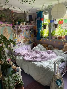 a bedroom with lots of plants and stuffed animals on the bedspread in it