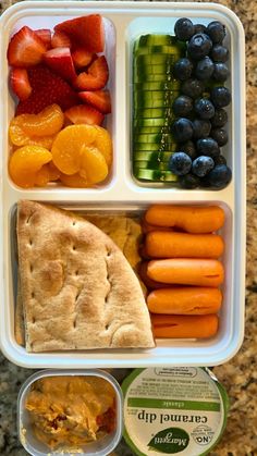 a lunch box filled with fruit, veggies and hummus