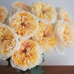 a glass vase filled with yellow and white flowers