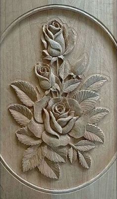 a wooden plaque with flowers carved into it