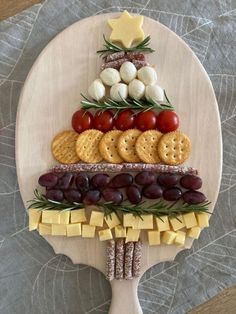 a platter with crackers, olives, tomatoes and cheese arranged in the shape of a christmas tree