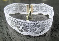 "\"Elegant Nostalgia: Vintage-Inspired White Lace Choker Necklace\" Indulge in timeless elegance with this exquisite vintage-inspired white lace choker necklace. The intricate lace design exudes a sense of delicate beauty, reminiscent of bygone eras. Each choker is meticulously crafted to capture the allure of vintage fashion, offering a touch of nostalgia to your ensemble. With a variety of designs available, you can choose the lace pattern that speaks to your personal style. Whether you prefer Classic White Choker For Party, White Classic Choker For Party, White Lace For Formal Occasions, White Lace With Lace Work For Formal Occasions, Delicate White Lace For Party, Delicate White Choker For Parties, Delicate White Choker For Wedding, Elegant White Choker For Anniversary, Vintage White Necklaces For Wedding