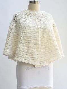 a white crocheted jacket on a mannequin