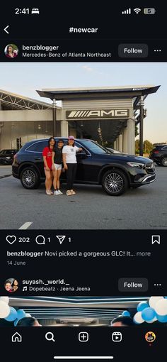 two people standing next to a black car in front of a building with an awning