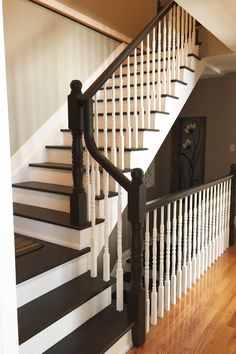 a staircase with white railing and black handrails in a home's entryway