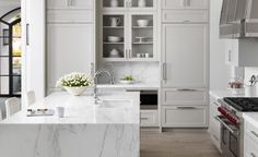 a kitchen with marble counter tops and white cabinets