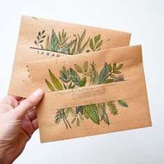 two brown envelopes with green leaves on them