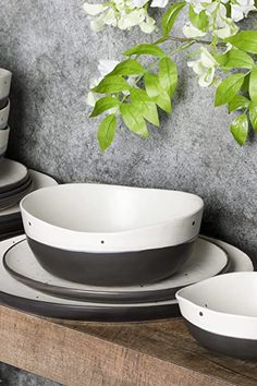 a table topped with plates and bowls next to a potted plant