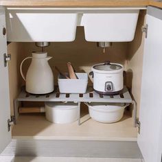 an open cabinet with pots and pans in it